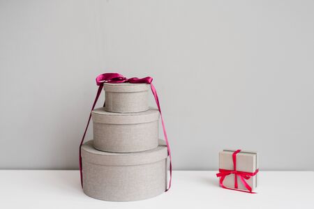 Christmas gift boxes on grey background: round and square birthday giftsの写真素材