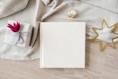 Beautiful wedding photo book in leather with embossed lace surrounded by gift box and stars on plaid and Board backgroundの写真素材