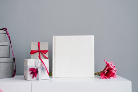 Beautiful wedding photo book in leather with embossed lace surrounded by gift boxesの写真素材