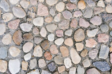 Stone paving on the sidewalk or road in the city, a background of stones and cementの写真素材