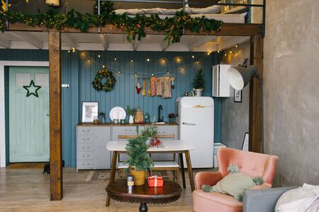 Beautiful Studio apartment in Scandinavian style, decorated for Christmas and New Year, kitchen and table with front doorの写真素材