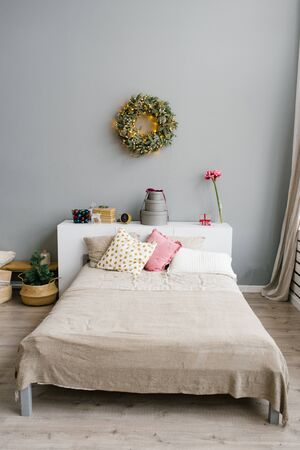 Double bed with bright pillows and decorated bedroom for Christmas or New Yearの写真素材