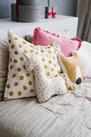 Funny handmade pillows, pillows in the form of animals on the bed in the bedroomの写真素材