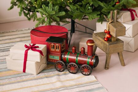Santa Claus Christmas Express toy and wooden old deer toy and gifts under Christmas treeの写真素材