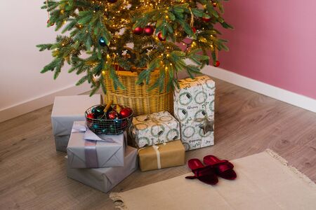 boxes with Christmas gifts are on the tree with lightsの写真素材