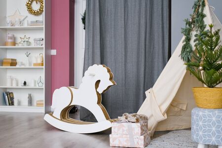 Children's toy rocking horse made of wood and cardboard in the children's room, decorated for Christmas and new yearの写真素材