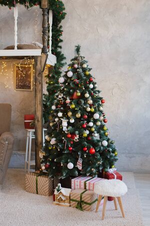 Beautiful traditional red Christmas tree in the interior of the living room of the houseの写真素材