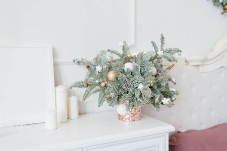 Beautiful Christmas composition of a Christmas tree with toys in the interior of a bright white bedroom, dining room or living room in the houseの写真素材