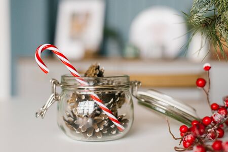 Cones in a glass jar and a lollipop cane close-up, Christmas decorの写真素材