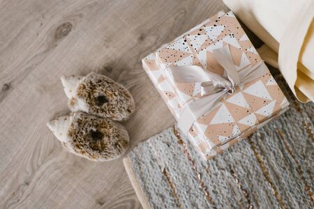 Gift boxes with a bow and children's slippers in the form of hedgehogsの写真素材