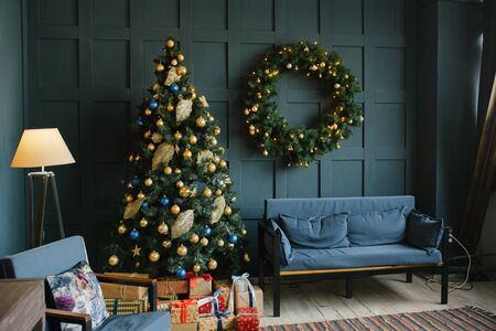 Blue sofa with pillows and Christmas wreath on the wall in the living room in the loft style.の写真素材