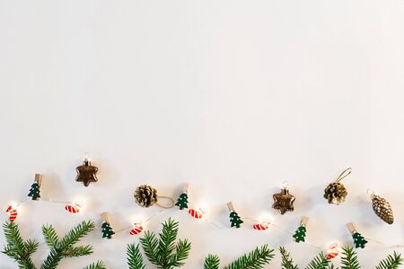 Christmas background with Christmas tree, cones and garland with lights on white background. Top view copy space. Christmas new year card. Copy spaceの写真素材