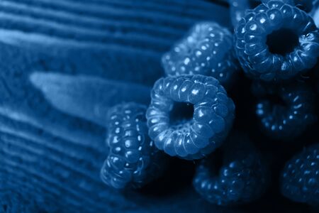 The color of the year 2020 is Classic blue. A handful of raspberries close up on a brown background. Copy spaceの写真素材