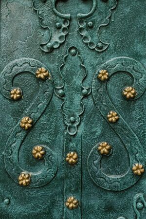 Lviv, Ukraine. October 2019. Elegant and beautiful patterns on the emerald - colored doors of the Dominican Cathedralの写真素材