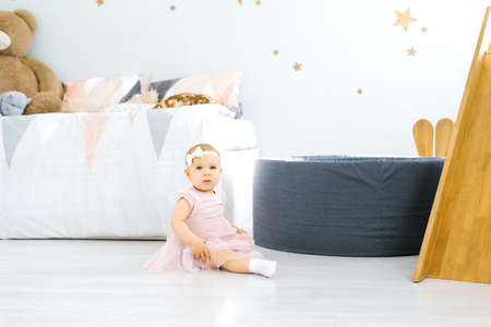 Child girl sitting on the floor in the children's room