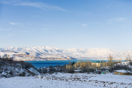 Charvak mountain lake in Uzbekistan on a snowy frosty day, surrounded by the Tien Shan mountainsの写真素材