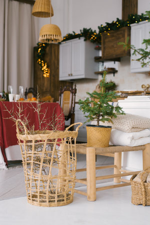 Wicker basket with dry branches in the dining room, decorated for Christmas and New Year in light and wooden colors. The kitchen in Scandinavian styleのeditorial素材