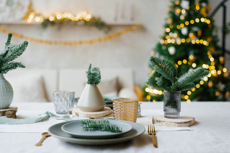 Decorated New Year's table in light turquoise colors. Vases with spruce branches on the background...