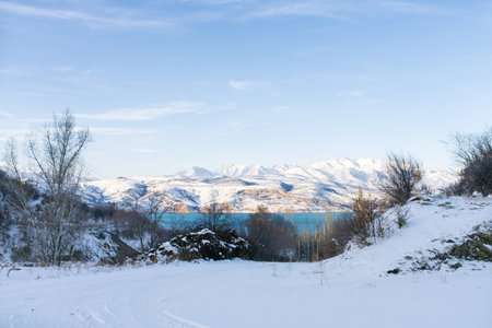 Mountain lake Charvak in Uzbekistan on a snowy frosty day, surrounded by the Tien Shan mountains.の写真素材