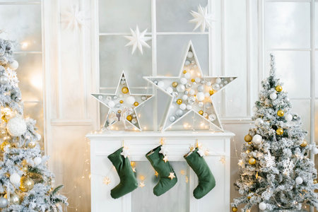 Christmas decor of the white fireplace in the living room. Fairy stars and socks for Santa Clausの写真素材
