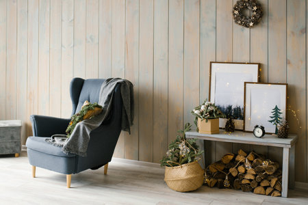 Scandinavian living room: an armchair with a blanket and a table with wood under itの写真素材
