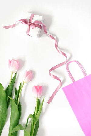 A bouquet of pink tulips, a gift box with a pink bow and a pink bag on a white background. Concept of Valentine's Day, Mother's Day, Birthday and Springの写真素材