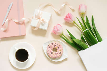 Tulips, gift box and coffee on a beige background. Flat lay. 8 March, International Women's Day....
