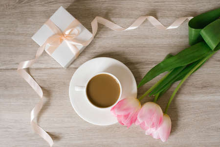 Pink spring tulips, a gift box and a cup of coffee. The concept of women's Day or mother's day. Flat lay. Spring festivalの写真素材