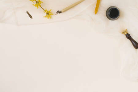 Calligraphy, sharp pen, ink, quills, vintage prints, forsythia flower and wax on beige background with copy spaceの写真素材