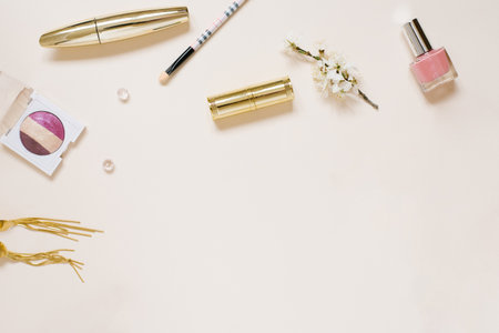 Beautiful flat lay arrangement with apple flowers, cosmetics and other accessories. Creative or beauty blogger mockup, beige background, copy spaceの写真素材