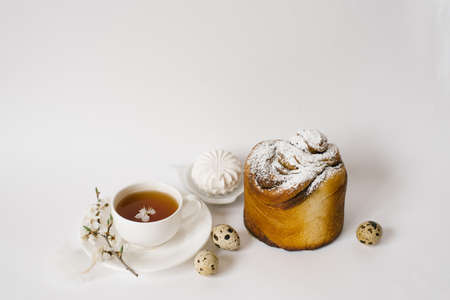 Easter sweet bread, cake and eggs with white apple flowers, a cup of tea. Festive breakfast concept with copy space.の写真素材