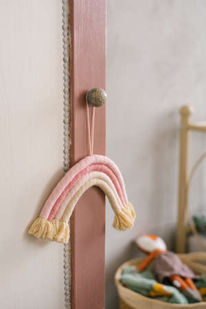 Rainbow thread hanging toy hanging on the handle of the wardrobe in the children's roomの写真素材