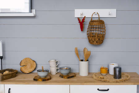 Modern kitchen interior with gray wooden panels on the wall in Scandinavian style, crockery and...