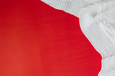 White knitted plaid on a red background in the corner. Flat lay. Copy spaceの写真素材