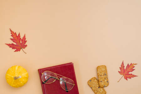 Autumn flat lay, top view of freelancer or blogger home office desk. workspace with pumpkin, leaves, cookies, notepad and glasses on a beige background, flat lay, top viewの写真素材