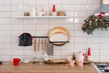 White festive kitchen - tiles on the wall, white refrigerator, red decor elements. Christmas home design.の写真素材