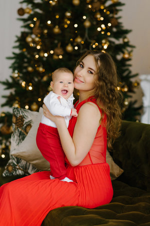 Happy Christmas celebration of a young mother and little son in the living room at the Christmas...