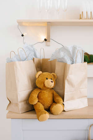 Soft toy bear near craft paper bagsの写真素材