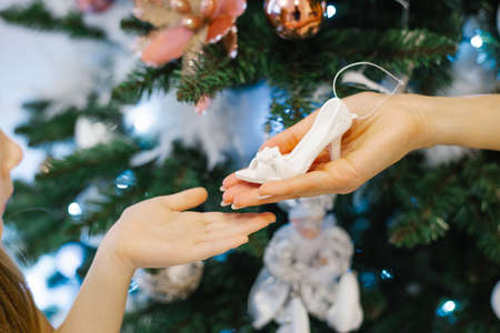 Mom passes her daughter a Christmas toy Shoe. Close-up of hands