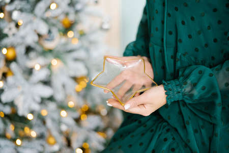 A woman holds a glass plate in the shape of a star. Close-up of handsの写真素材