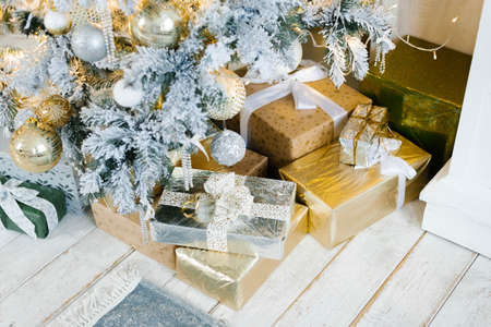 Silver and gold gifts for Christmas and New Year under the treeの写真素材