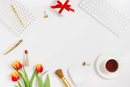 Postcard for Valentine's Day, Mother's Day or March 8. A bouquet of tulips, a gift with a red bow, a cup of tea, cosmetics and a notebook with a pen. Falt lay blogger with copy spaceの写真素材