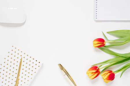 Valentines desktop background with red tulip, notebook, cosmetic, pen. Valentine's Day greeting card. Female blogger workplace. Top view with copy spaceの写真素材