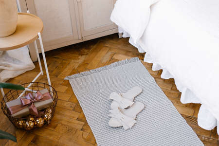 Stylish women's home slippers are located near the bed. Top view