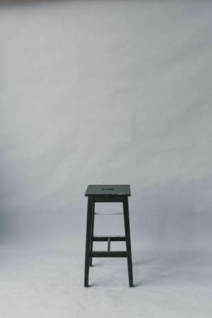 black stool stool on a gray paper background in a photo studioの写真素材