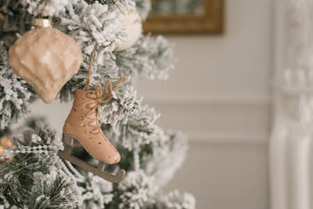 A toy in the form of a skate hangs on a silver Christmas tree with a copy spaceの写真素材