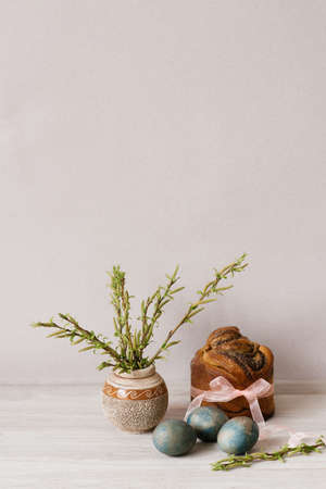Easter or Palm Sunday. Painted chicken eggs. Blue eggs on a light wooden table. An Easter cake tied...
