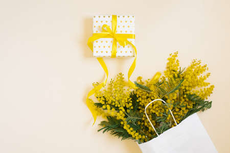 Yellow mimosa flowers frame with gift box. Woman's day, easter, spring composition. top view with copy spaceの写真素材