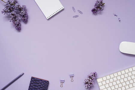 The workspace of a blogger or freelancer Flat lay with a keyboard, notebooks and lilac branches,...
