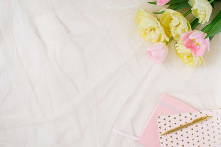 Notebook, pen with tulip flowers. Top view, flat lay. Abstract feminine concept. spring mockup...
